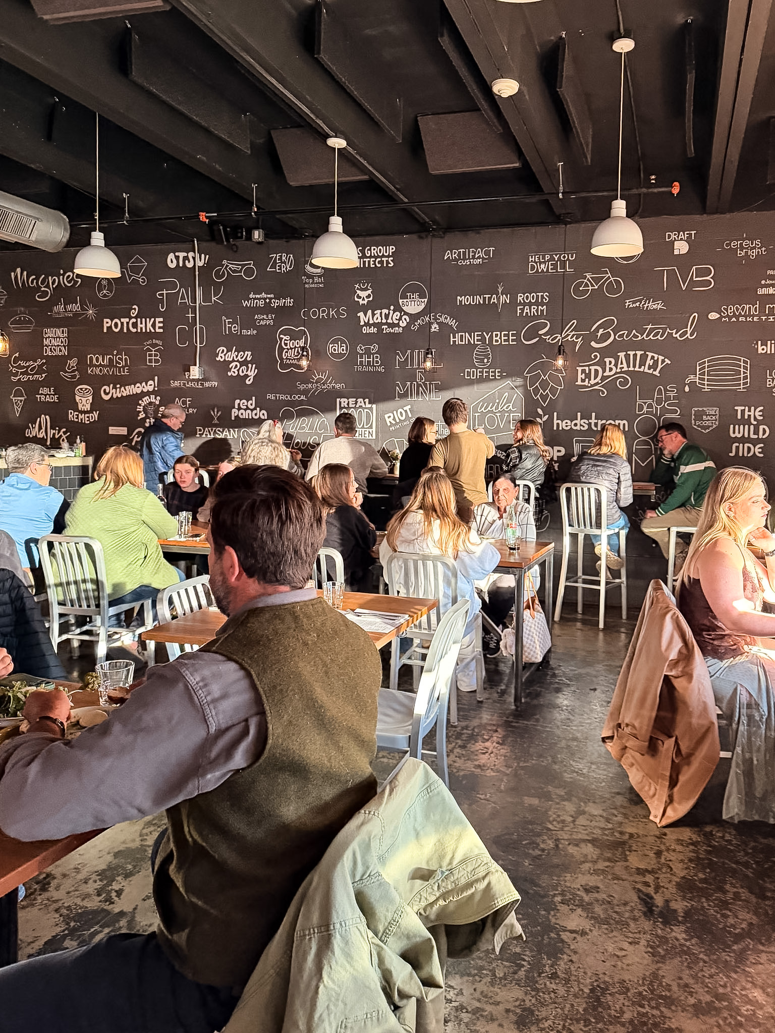 A Dopo Knoxville dining table with pizza and wine