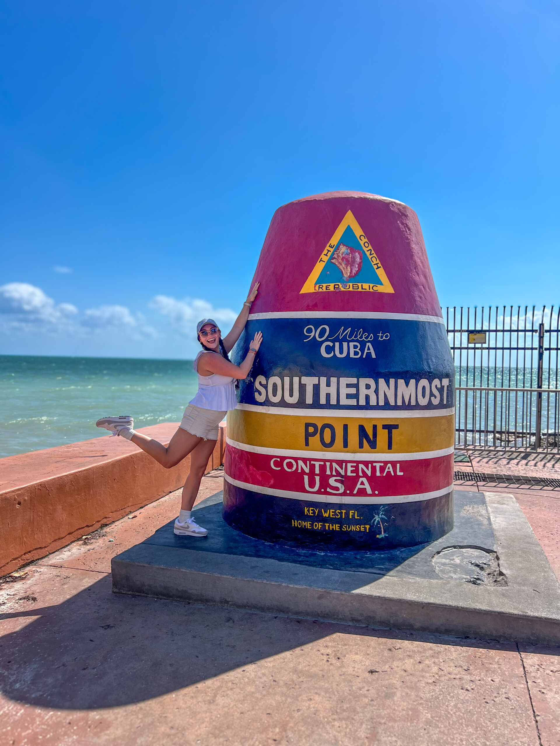 Best photo spots in Key West at the Southernmost Point buoy with palm trees nearby