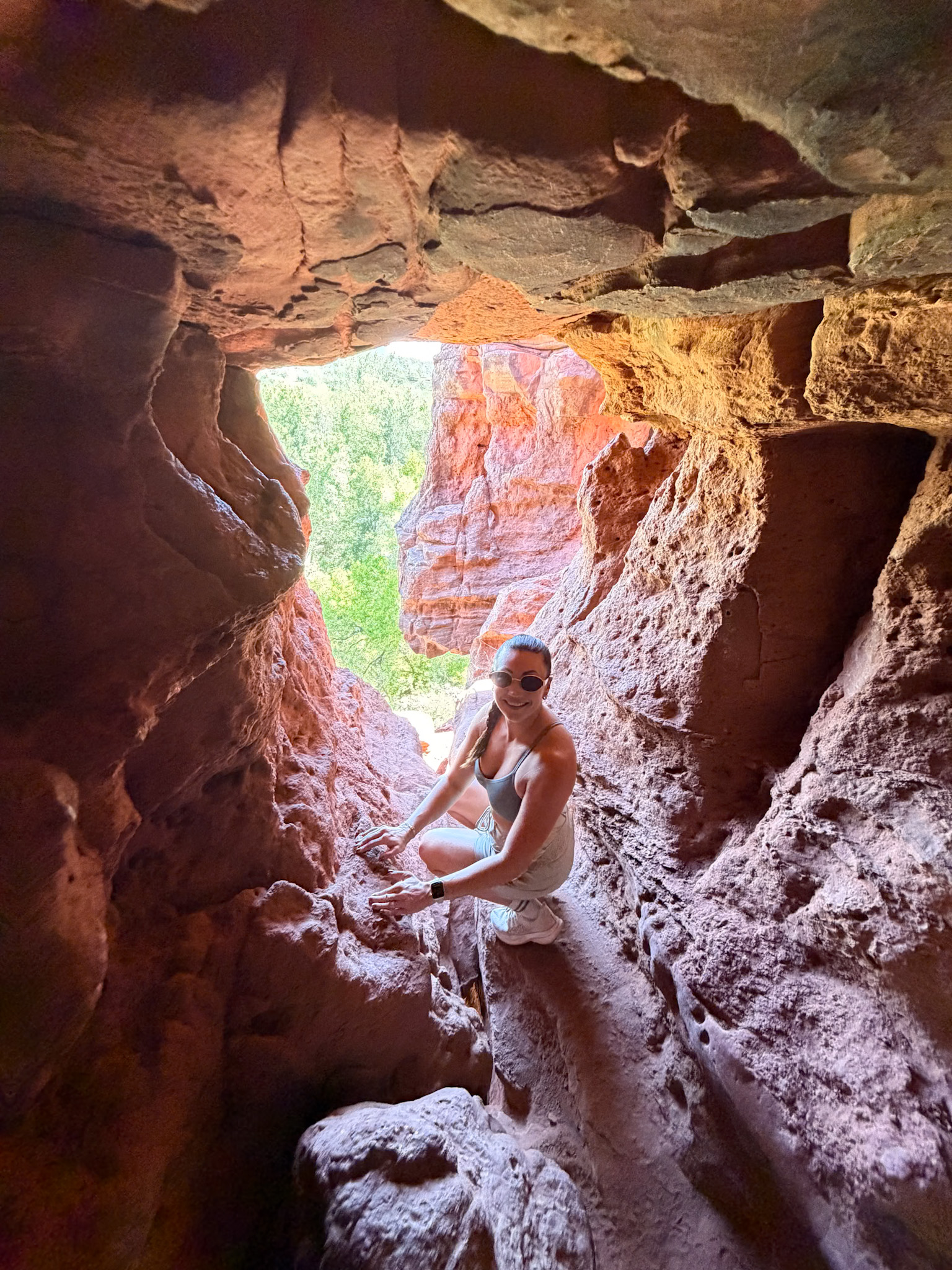 Hiker exploring the natural openings at Raven’s Cave Sedona
