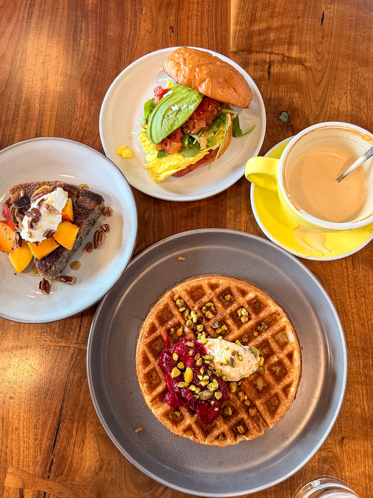 Stowaway Kitchen Denver brunch table with waffle, cornbread, and breakfast sandwich