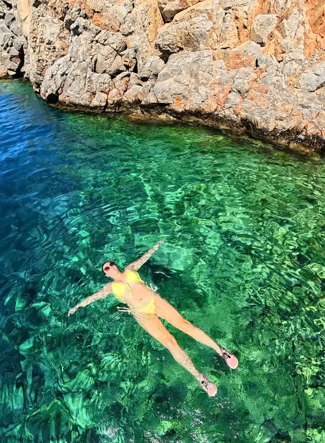 Rocky beach entry and turquoise water at Avlaki Beach during our one day in Hydra Greece.