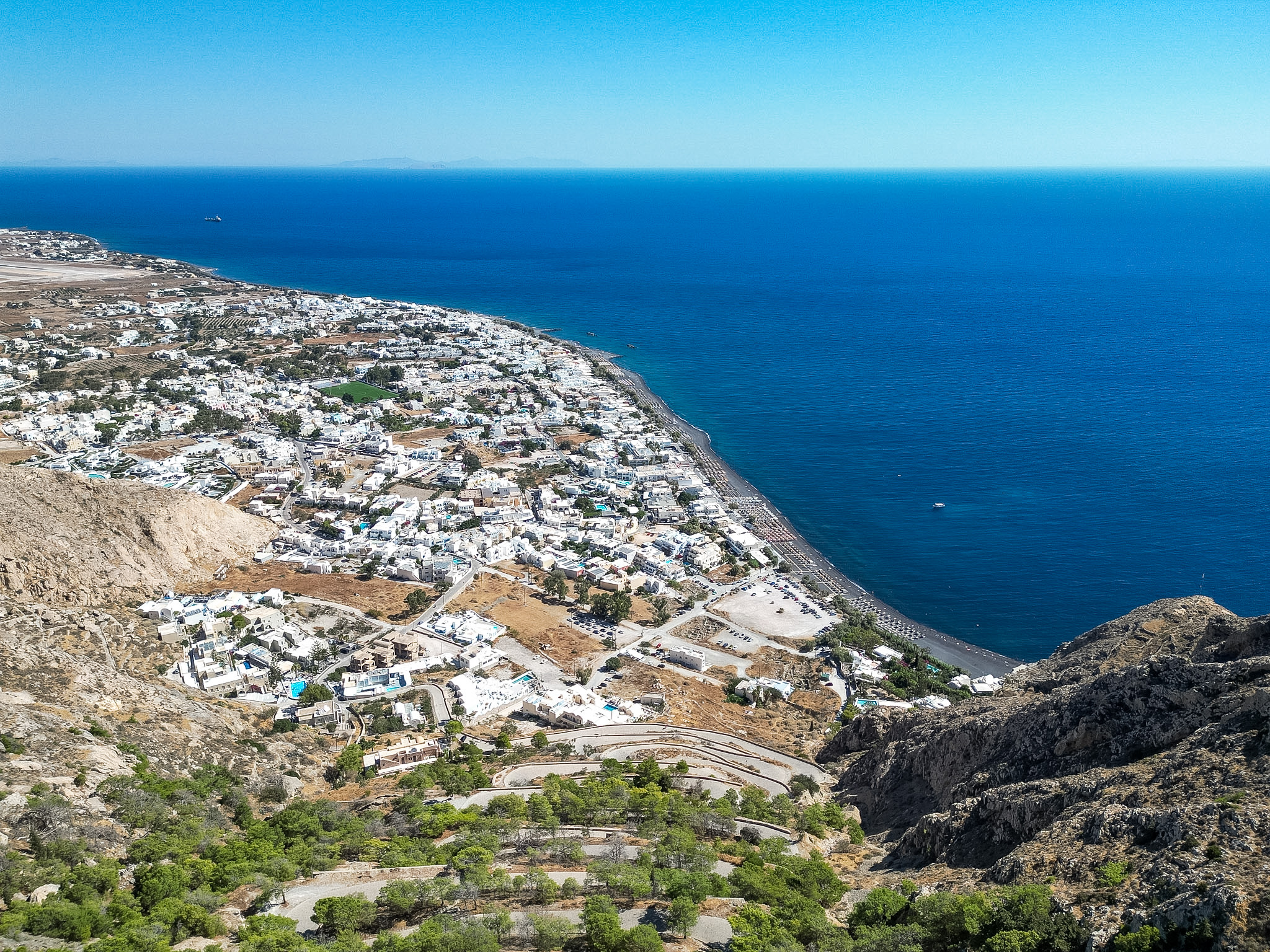 Kamari Santorini black volcanic beach with umbrellas and the Aegean Sea
