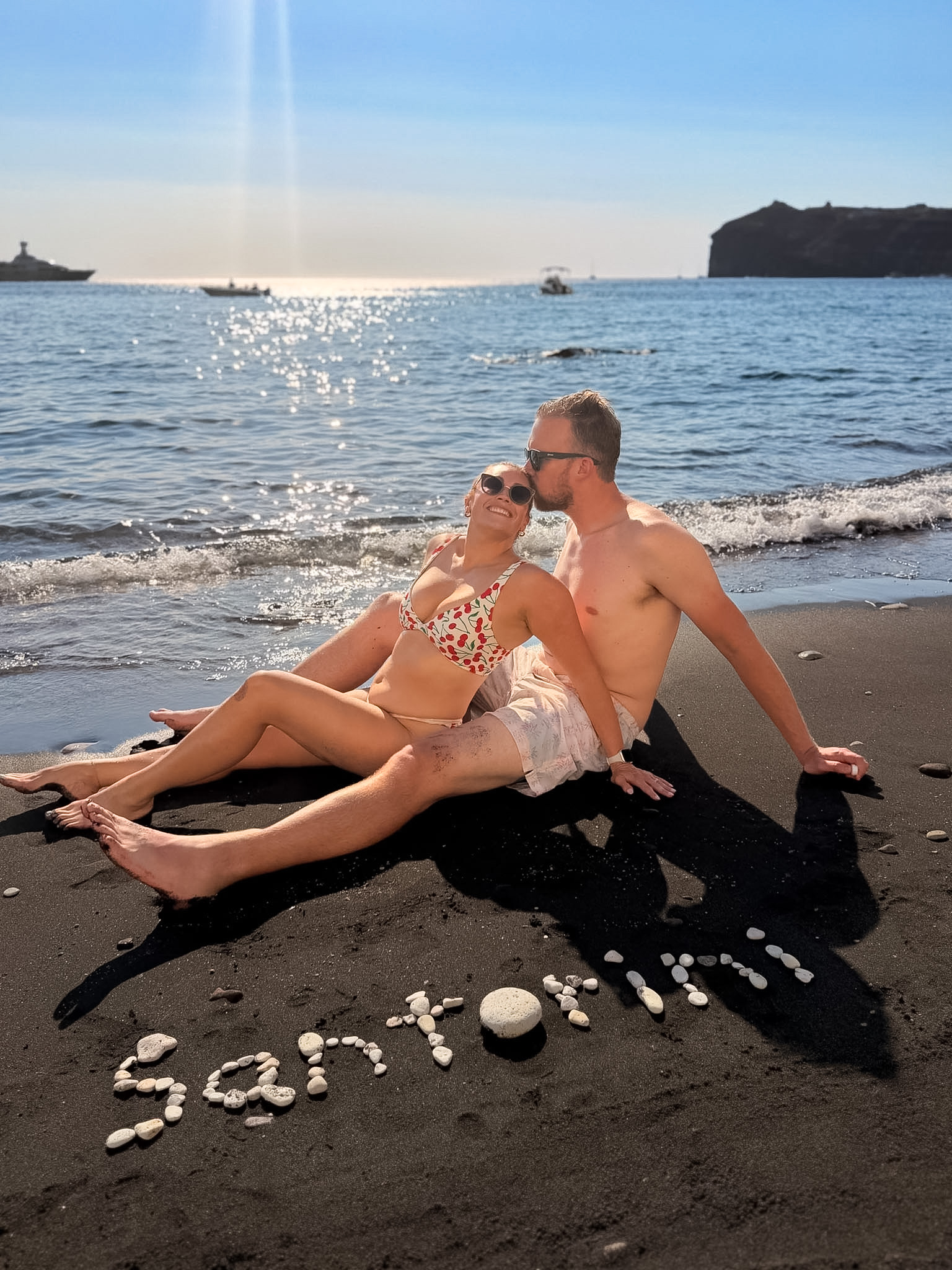 Dark volcanic pebbles and rocky coastline near White Beach Santorini