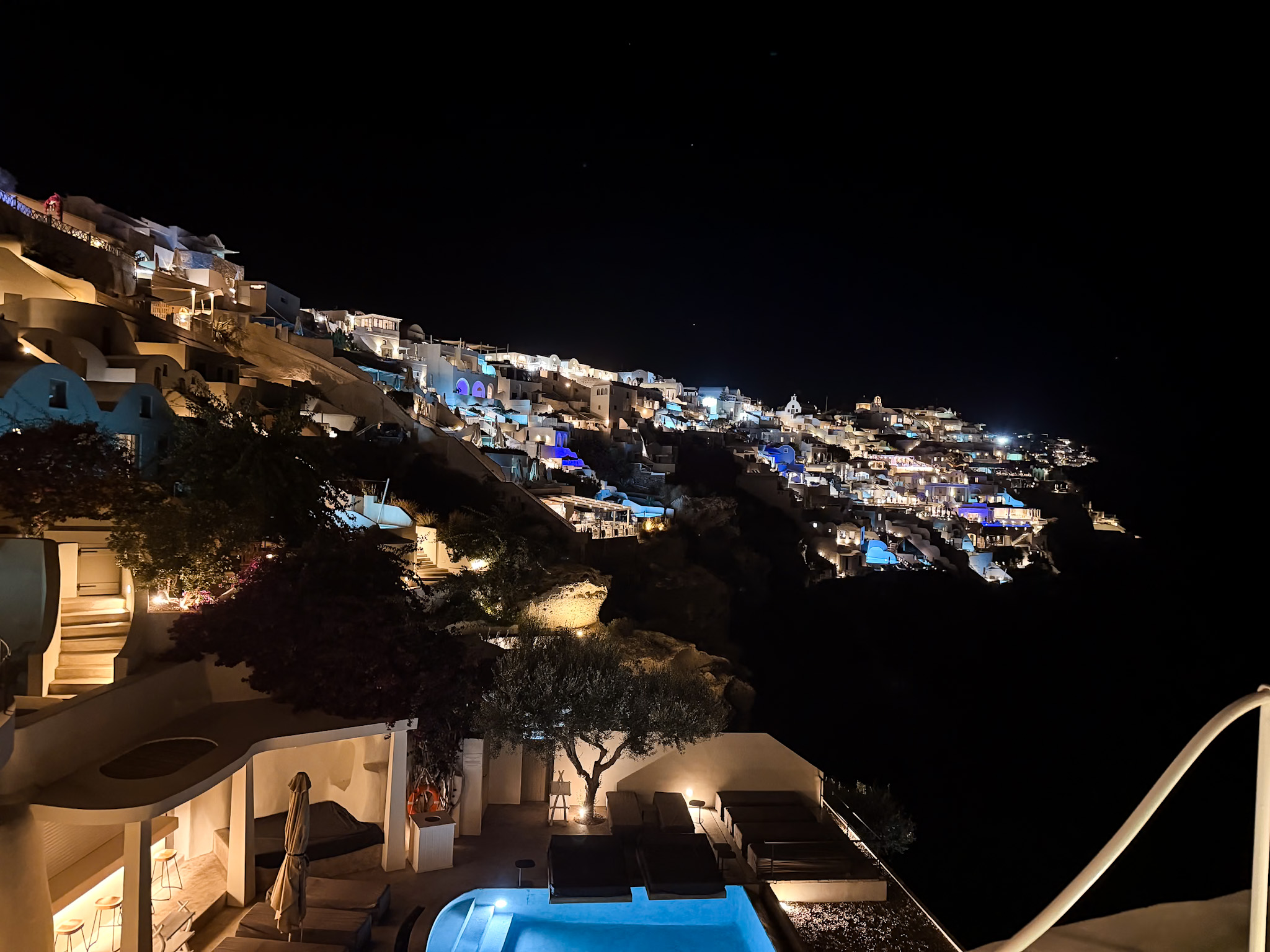 Oia village illuminated after dark as seen from Lycabettus Restaurant